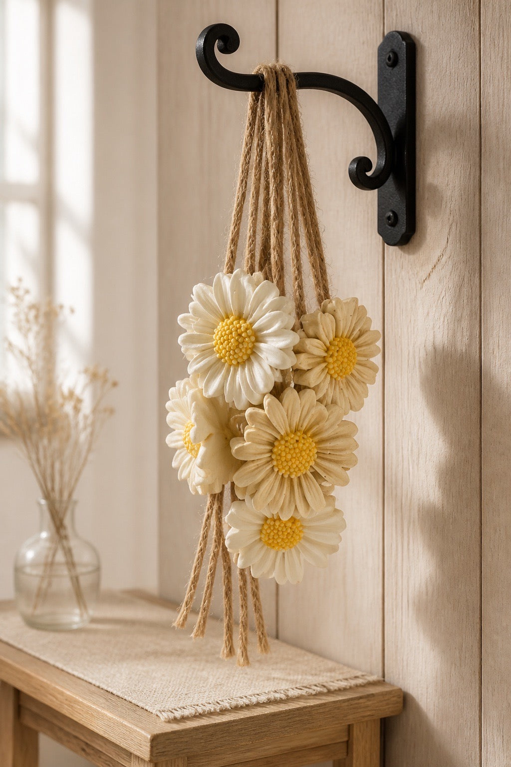Decorative soap wall hanging with flowers and jute rope on a wooden surface and wall.